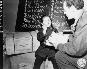Harry Weinsaft of the American Jewish Joint Distribution Committee, gives food to three-year-old Renati Rulhater, a Jewish DP child in Vienna, Austria, 1945.